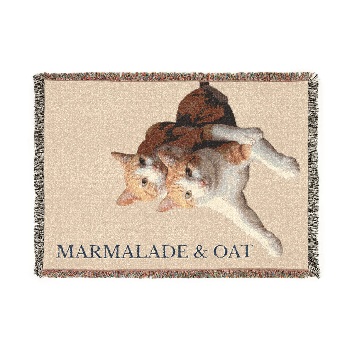 Custom woven pet portrait blanket with two cats on a Cream background, fringed edges, and Marmalade & Oat text, shown in full